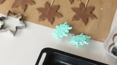 Kadın zencefilli ekmek hamurunu dağıtıyor. Çubukta zencefilli çörek. Kar taneleri ve yıldızlar şeklinde zencefilli ekmek. Yakın plan...