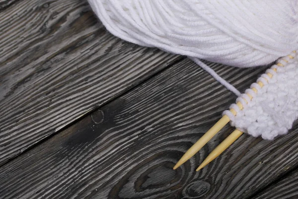 用木针编织 一缕白线和针织产品的碎片 在黑松木板上四 后续行动 — 图库照片