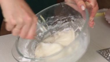 Bir kadın bal ve jelatin ekleyerek pudra şekerini karıştırıyor. Hamur işi mastiği yapıyor. Yakın plan..