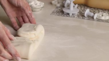 Bir kadın pudra şekerinden şekerleme mastiği yapar. Elleriyle diz çöküp pudra şekeri ekliyor. Yakın plan...