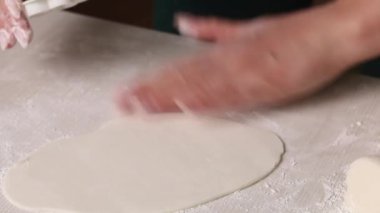 Bir kadın pudra şekerinden şekerleme mastiği yapar. Maskeyi açtım ve rakamları kestim. Yakın plan.