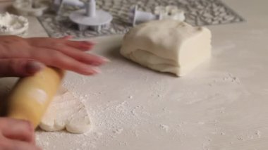 Bir kadın pudra şekerinden şekerleme mastiği yapar. Merdaneyle yuvarla, pudra şekeri ekle. Yakın plan..