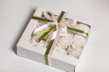 Hediye kutusunda ev yapımı marşmelov. Fiyonka bağlanmış bir kurdeleyle bağlanmış. Beyaz bir arka planda. Yakın plan..