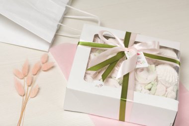 Hediye kutusunda ev yapımı marşmelov. Fiyonka bağlanmış bir kurdeleyle bağlanmış. Beyaz bir arka planda. Yakın plan..