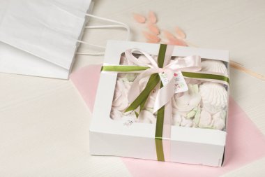 Hediye kutusunda ev yapımı marşmelov. Fiyonka bağlanmış bir kurdeleyle bağlanmış. Beyaz bir arka planda. Yakın plan..