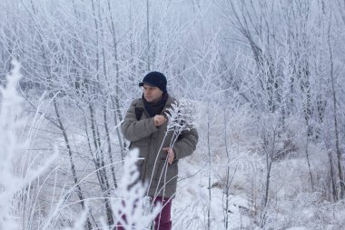 Kışın giyinmiş bir adam. Etrafta karla kaplı bir manzara var. Erkek portresi. Yakın plan.