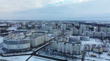 Flying in a suburban park. City blocks are visible. Winter cityscape. Aerial photography.