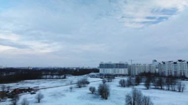 Flying in a suburban park. City blocks are visible. Winter cityscape. Aerial photography.