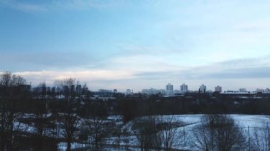 Flying in a suburban park. City blocks are visible. Winter cityscape. Aerial photography.