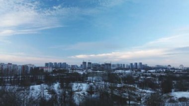 Flying in a suburban park. City blocks are visible. Winter cityscape. Aerial photography.