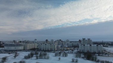 Flying in a suburban park. City blocks are visible. Winter cityscape. Aerial photography.