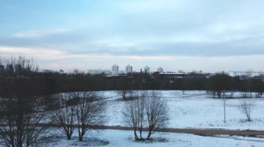Flying in a suburban park. City blocks are visible. Winter cityscape. Aerial photography.