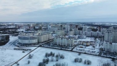 Flying in a suburban park. City blocks are visible. Winter cityscape. Aerial photography.