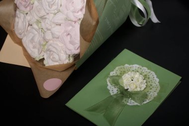 A bouquet in craft paper and a greeting card. Marshmallow bouquet. Roses from marshmallows. Close-up.