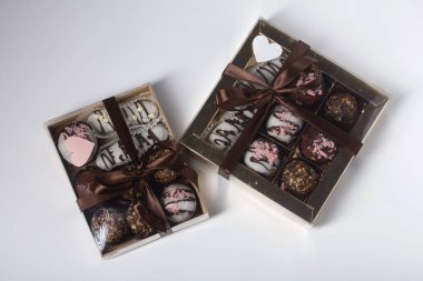 Candies in chocolate glaze. In a gift box. Tied with a ribbon tied into a bow. On white background.