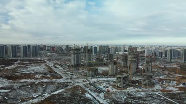 建設現場だ 近代的な高層ビルの建設 工事用クレーン 雪に覆われた地球 空中写真 — ストック動画