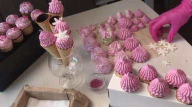 Bir kadın waffle külahlarını mısır gevreğiyle süslüyor. Genel plan