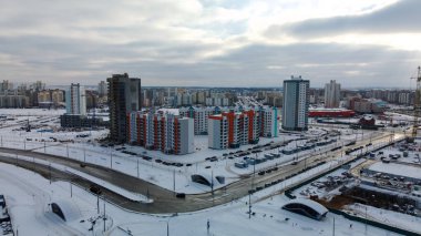 Modern bir şehir bloğunun inşaat alanı. Yüksek binalar yapım aşamasında. İnşaat kulesi vinçleri. Kışın inşaat alanında. Gün batımında hava fotoğrafçılığı.