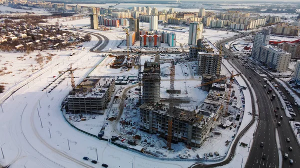 近代的な都市ブロックの建設現場 高層ビルの建設中 建設タワークレーン 冬の建設現場 日没時の空中写真 — ストック写真