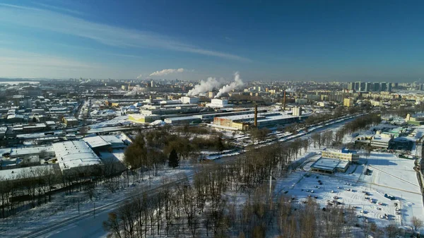 市の郊外の工業地帯 工場の建物は雪で覆われている 工場パイプが見えます 冬の産業風景 空中写真 — ストック写真