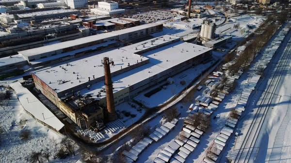 城市郊区的工业区 工厂的建筑物被雪覆盖着 工厂的管道是可见的 冬季工业景观 空中摄影 — 图库照片