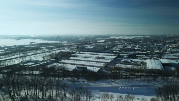 雪に覆われた工場の建物 鉄道だ 夕日のバックライトで 冬の産業風景 空中写真 — ストック動画