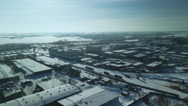 雪に覆われた工場の建物 鉄道だ 夕日のバックライトで 冬の産業風景 横に飛んで 空中写真 — ストック動画