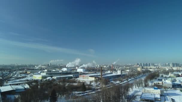 雪に覆われた工場の建物 工場の煙煙突 近くに鉄道がある 街のブロックが見えます 冬の産業風景 空中写真 — ストック動画
