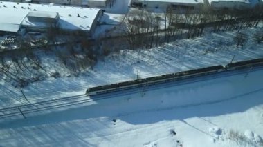 Demiryolu üzerinde uçuş. Bir tren raylar boyunca çalışır. Kış endüstriyel manzarası. Hava fotoğrafçılığı.