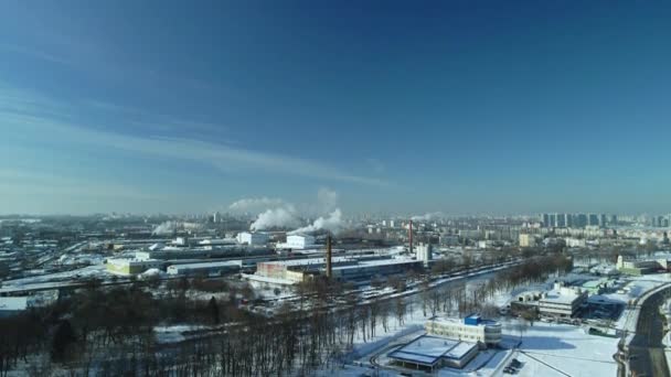 雪に覆われた工場の建物 工場の煙煙突 近くに鉄道がある 街のブロックが見えます 冬の産業風景 空中写真 — ストック動画