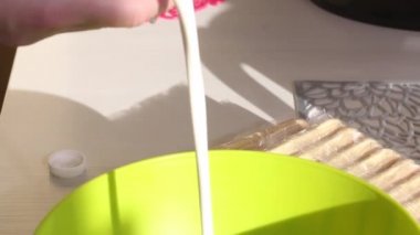 Bir kadın pasta için krema yapar. Savoiardi kurabiyeli kek ve marshmallow gülleri. Yakın plan..