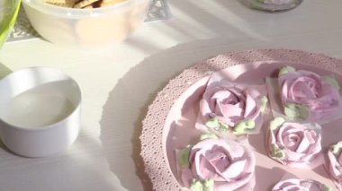 Bir kadın pasta için krema yapar. Savoiardi kurabiyeli kek ve marshmallow gülleri. Malzemeler masanın üzerine serildi. Yakın plan.