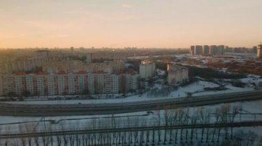 Büyük bir şehrin banliyösü. Uçuşun yüksekliğinden bir blok ötede. Yoğun trafiği olan şehir otoyolu. Kış şehri manzarası. Gün batımında altın saat. Hava fotoğrafçılığı.