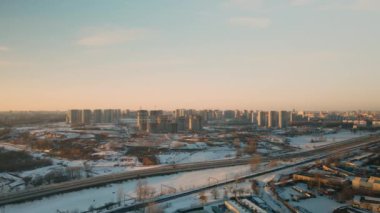 Büyük bir şehrin banliyösü. Uçuşun yüksekliğinden bir blok ötede. Yoğun trafiği olan şehir otoyolu. Kış şehri manzarası. Gün batımında altın saat. Hava fotoğrafçılığı.