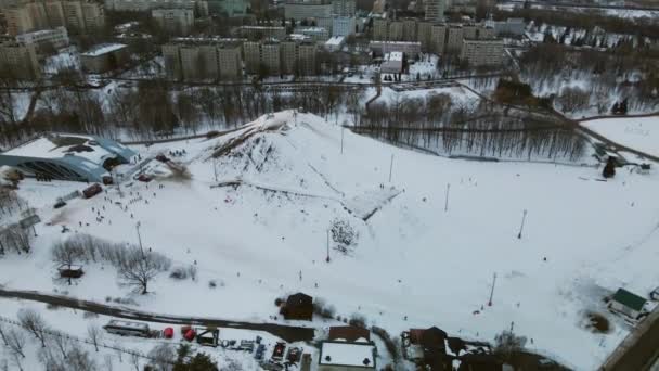 一个大城市的郊区 城市街区从飞行的高度 滑雪场滑雪场公园里的池塘 冬天的城市景观 日落时的黄金时刻空中摄影 — 图库视频影像