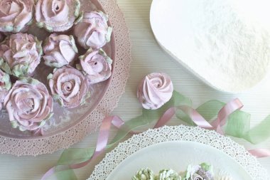 Güller, laleler ve marşmelovlardan kasımpatılar. Zephyr çiçekleri. Üzerine pudra şekeri serpilmiş..