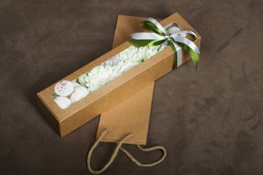 Güller, laleler ve marşmelovlardan kasımpatılar. Zephyr çiçekleri. El işi ambalajında. Kurdeleyle bağlanmış.