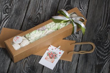 Güller, laleler ve marşmelovlardan kasımpatılar. Zephyr çiçekleri. El işi ambalajında. Kurdeleyle bağlanmış.