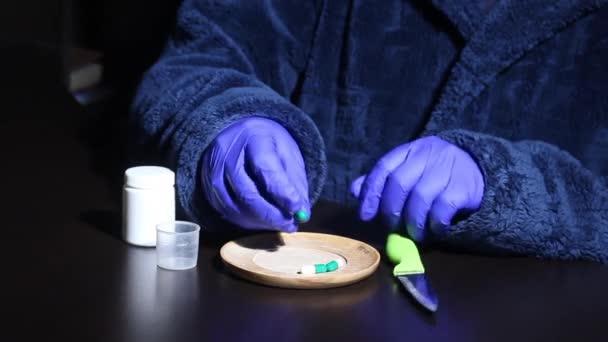 病気の男は薬箱に様々な薬を入れます 暖かい屋形船とゴム手袋の男 テーブルランプの光の下で 中期計画 — ストック動画