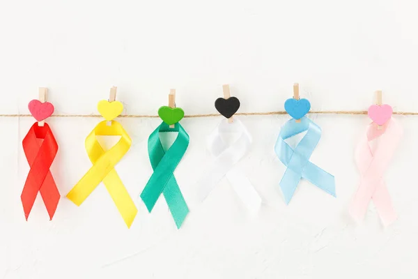 Colored cancer ribbons on clothespins. lizenzfreie Stockfotos