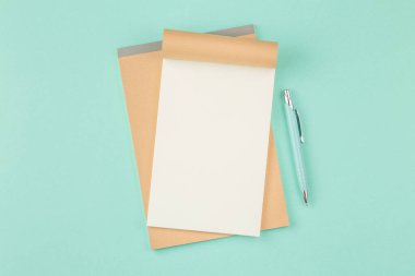 Yeşil arkaplanda kalemle birlikte not defterini aç