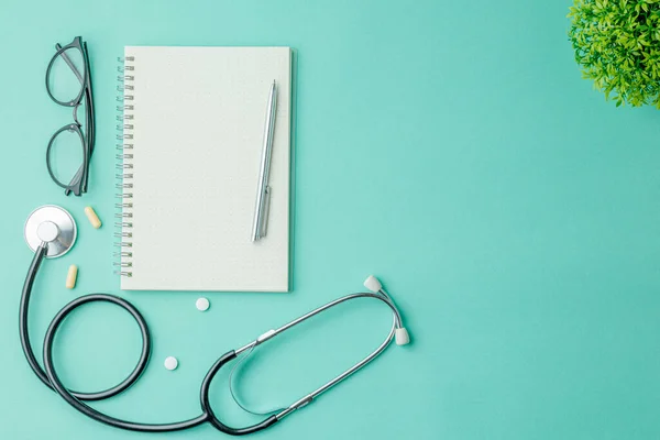 Aufgeschlagenes Notizbuch Mit Stift Und Brille Auf Grünem Krankenhaushintergrund Lag lizenzfreie Stockbilder
