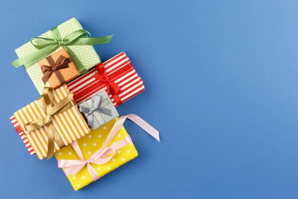 Geschenke Buntem Geschenkpapier Mit Schleifen Auf Blauem Hintergrund Flach Lag lizenzfreie Stockfotos