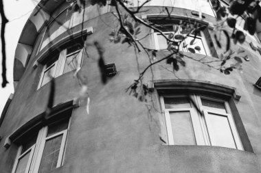 Dibe bakan beton gökyüzü kulesi ortaçağ şövalye şatosu deniz feneri stili yapıyor. Büyük pencere gri duvarı. Siyah beyaz etkisi. Alışılmadık mimari güzellik Çatı çözüm şehir inşaatı