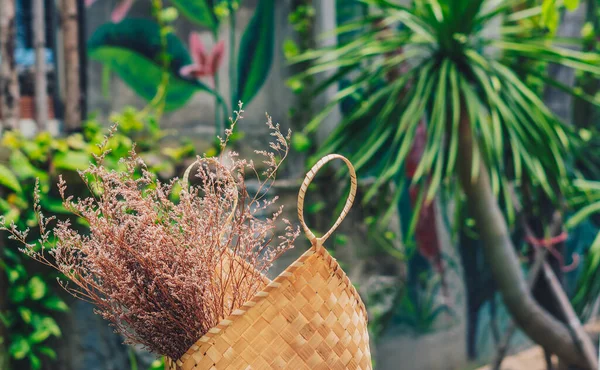 Real nature beauty background. Copy space Close-up bag beach straw with dry flower grass for decor design outdoor place. Tropical green background. Summer trend, sun calm mood, relaxation travel — Stok Foto