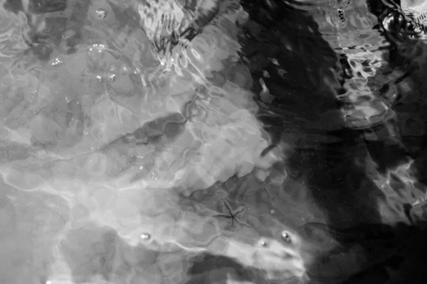 Αφηρημένη πραγματική ομορφιά φόντο της φύσης. Ωκεανό bokeh επιφάνεια κύμα κυματισμός. Σκιά υφή υποβρύχιου βάθους άμμος μέσα από νερό υγρό. Μαύρο λευκό μονόχρωμη αντίθεση φωτογραφία εικόνα Σύγχρονη σχεδίαση — Φωτογραφία Αρχείου