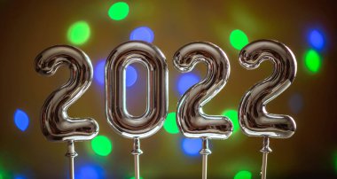 Bokeh 'in arka planında 2022 model gümüş sayılar var. Yeni yıl için tebrikler kavramı.