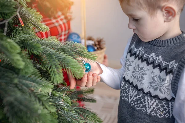 子供と一緒にクリスマスツリーをおもちゃやボールで飾るお母さん 新年のための家族の準備の概念 居心地の良い雰囲気とお祭り気分 — ストック写真