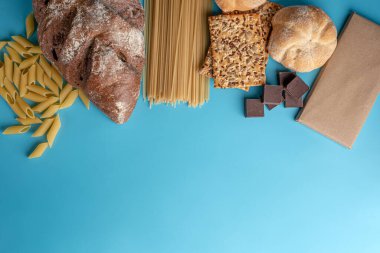 Ekmek, makarna, mavi arka plan manzaralı çikolata. Çevrimiçi alışveriş konsepti, teslimatlı taze ürünler. Boşluğu kopyala.