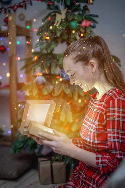 Mladá Žena Červených Šatech Vedle Vánočního Stromečku Otvírá Dárkovou Krabici — Stock fotografie